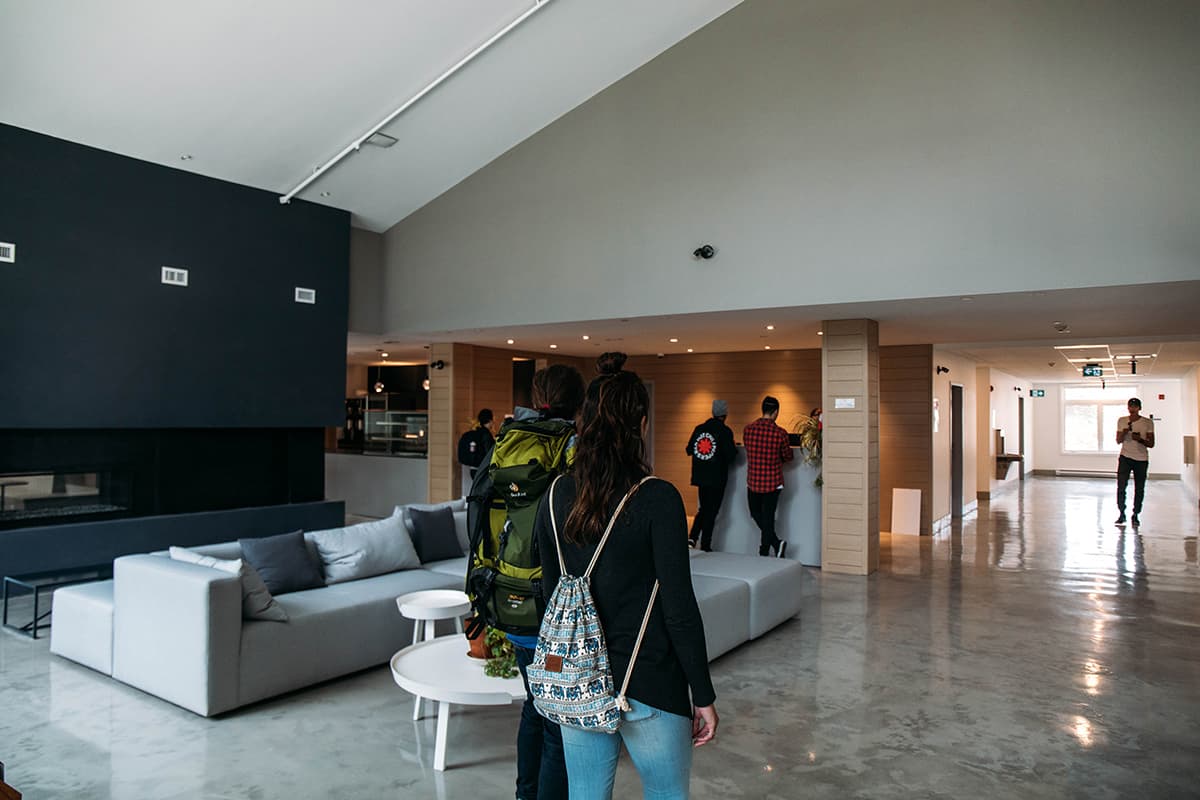 an image of the main lobby at the HI Jasper Hostel. with couches and people walking through